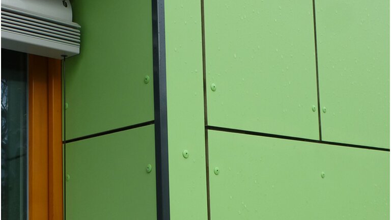 Gebäude mit grüner Fassade, schwarze Profile